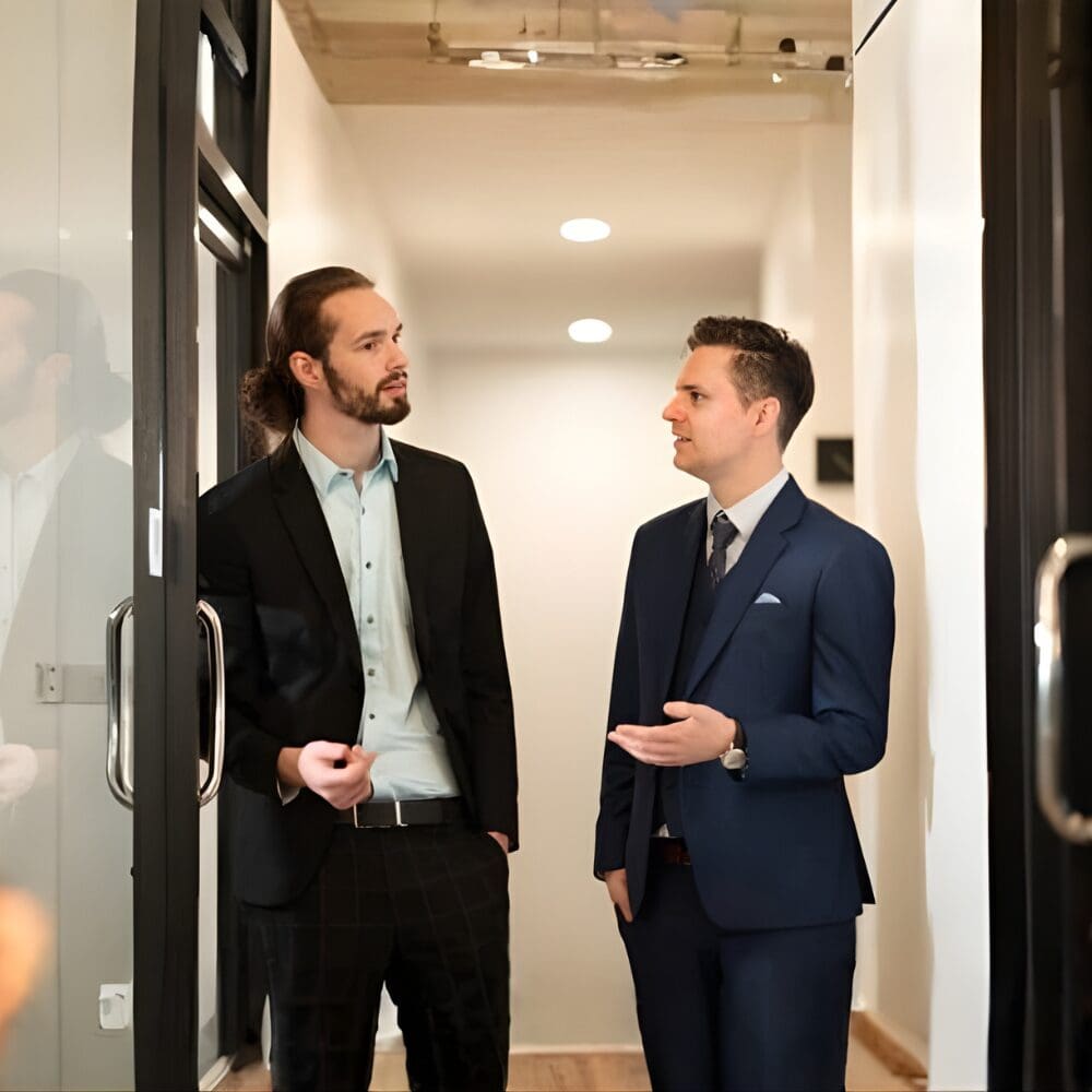 Two professionals chatting in office hallway