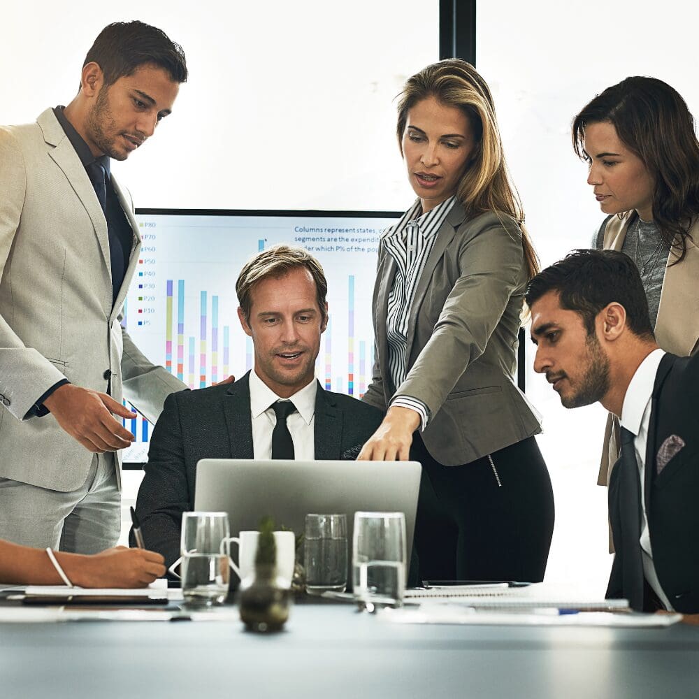 Business team reviewing data on laptop