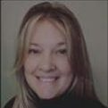 A woman with long hair smiles for the camera.